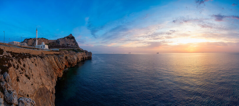 Europa Point Lighthouse with sea in background. Colorful Cloudy Sunrise Sky. Gibraltar, United Kingdom. Panorama