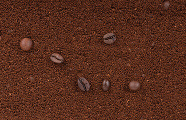 Full frame of coarsely ground coffee and a few coffee beans on top.