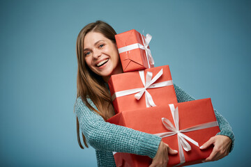 Happy woman in green sweater holding pile of red gift boxes. Advertising female studio portrait.