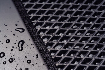 Close up view of a new all season eva car mat with water drops.