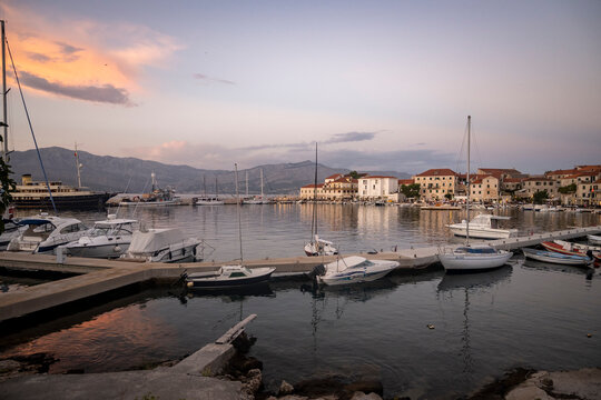 Beautiful sunset over small town of Postira on Brac island, Croatia and port with anchored boats