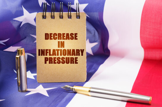 Against the background of the American flag is a notepad with the inscription - decrease in inflationary pressure