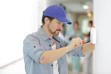 handsome young electrician repairing intercom © auremar