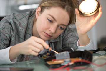 young woman repairing electronic board
