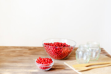 Red currants in bowl preparing for making jam in jar at kitchen.peeling fruits.Natural,healthy berry