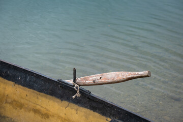 Boat parked on the shore of a lake. old wood oar.