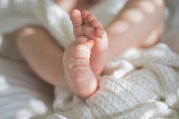 Baby feet in spots of sunlight