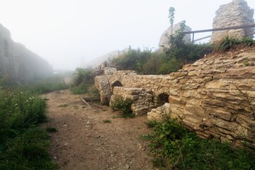 Entrances to the underground in the upper courtyard in a foggy morning. The ruins of the Stary Jicin castle. Eastern Moravia. Czechia.