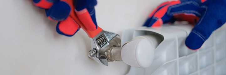 Plumber blocks repair of radiators of heating battery in tap of apartment