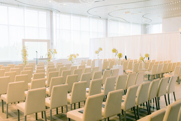 Festive empty location for wedding ceremony in light colors with a lot of chairs for guests