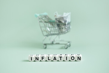 Shopping basket cart with dollars cash and word Inflation on blue background. Inflation financial...
