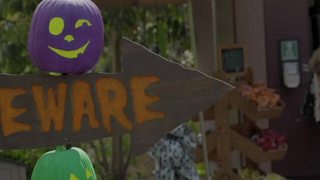 This video shows a halloween "beware" sign with directional arrows and colorful pumpkin jack-o'-lanterns.
