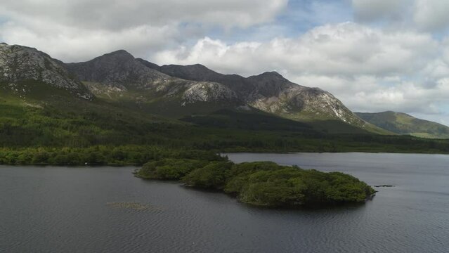 Aerial flyover view of lake and trees at Lough Inagh / Galway, Ireland