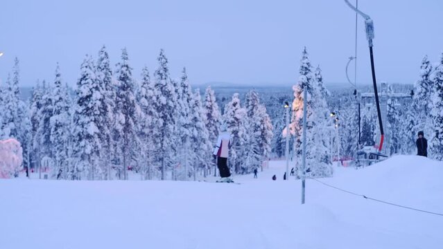 group, skiers and snowboarders on the top of snowy mountain, preparation for ascent from slope in Levi ski resort, tourism, winter sports, beautiful winter landscape, Levi, Finland - January 2022