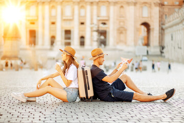 Tired tourists looking at a map and drinking coffee take away. vacation in Rome, Italy. tourists choose a hotel. tourists looking for a direction on a map. an emigrants. moving to a new country. 