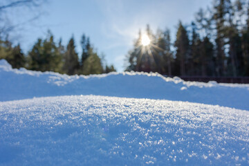 Obraz premium Winter Merry christmas and happy new year background. Beautiful snowdrifts with light, snow flakes, forest and sun with rays. Copy space, banner. High quality photo