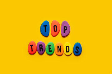 Top trend, forecasting, process of researching and formulating predictions on consumers future buying habits, Whats new in business. Text Top trends from color blocks on yellow background.