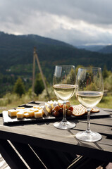Two glasses of white wine and cheese outdoor