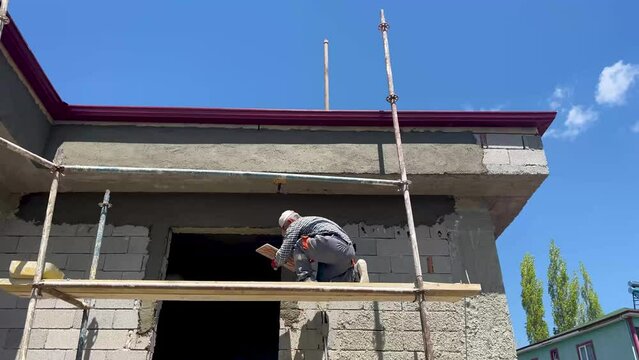 The master plastering the exterior of the building