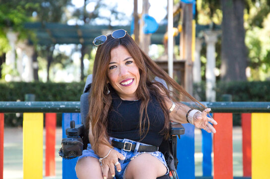 young disabled woman in a wheelchair with reduced mobility sightseeing in a city. Concept of equality and solidarity