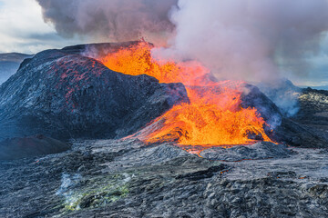 Volcanic landscape in Iceland. active volcano on Reykjanes Peninsula in GeoPark. Volcanic crater during eruption with strong lava flow. glowing lava with heavy smoke over the crater