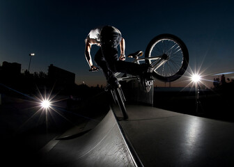 boy with his BMX bike at dusk at a skatepark