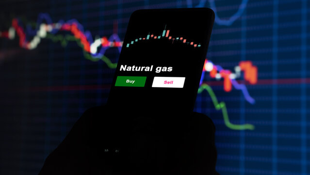 An investor's analyzing the oil etf fund on screen. A phone shows the ETF's prices uls oil energy to invest
