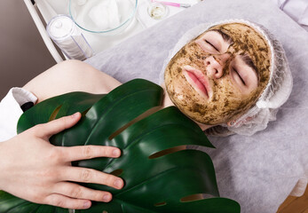 Herbal face mask, spa beauty treatment, skin care, deep cleansing. Woman getting herbal face...