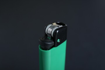 Stylish small pocket lighter on black background, closeup