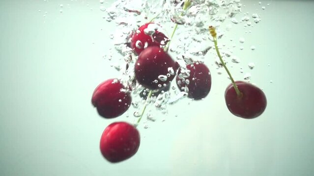 Falling of sweet cherry in water. Slow motion.