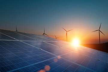 Solar panels with wind turbines against sunset sky background. Photovoltaic, alternative...