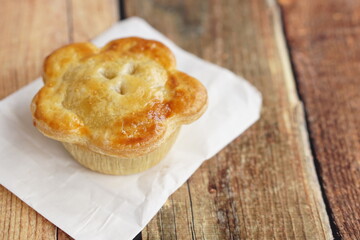 English pie with crispy puff pastry close up on the table.