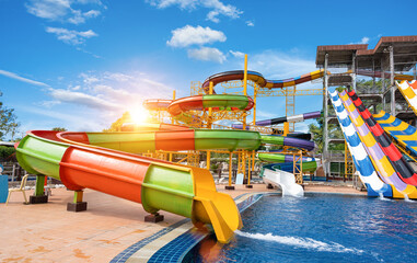 Swimming pool with water slides in aqua park on sunny day. summer fun activity, vacation leisure concept.
