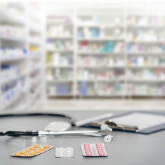 Different prescription medical pills and stethoscope on pharmacy shop background