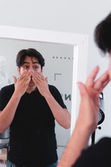High quality photography. Boy cleaning his face with personal care products. Skin care.