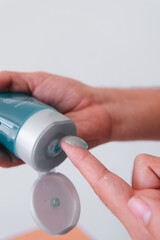 High quality photography. Blue cream on a finger to place it on the face to tone. Skin moisturizer.