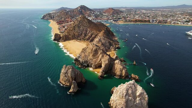 Aerial view overlooking the rocky arch of Cabo San Lucas, sunny Mexico - tilt, drone shot