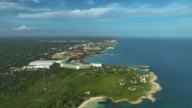 Aerial view overlooking resorts on the coast of sunny Xpu-Ha, Mexico - reverse, drone shot