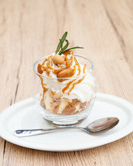 Homemade vanilla ice cream parfait with nutty, caramel sauce, whipped cream and cookie crumble