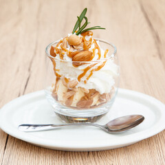 Homemade vanilla ice cream parfait with nutty, caramel sauce, whipped cream and cookie crumble