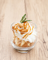 Homemade vanilla ice cream parfait with nutty, caramel sauce, whipped cream and cookie crumble