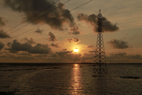 Sunset view from a lake side, powerlines passing above lake