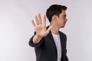 Portrait of young handsome businessman doing stop sing with palm of the hand over white background