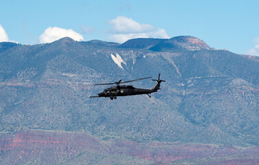 Fototapeta na wymiar A single Army helicopter flying with a mountain in the background
