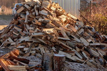 a large pile of chopped wood lies on the ground