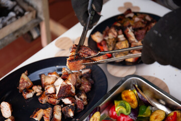 Close up shot of man hand using scissors to cut grilled pork on the dish  