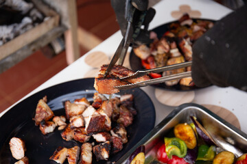Close up shot of man hand using scissors to cut grilled pork on the dish  