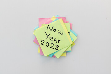 New year 2023 hand written on a yellow sticky note with isolated white background