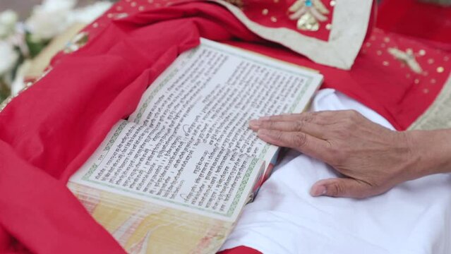 Close-up of hand passes over the text of holy Indian religious book