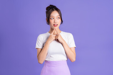 Portrait of a beautiful Asian woman posing on a purple background